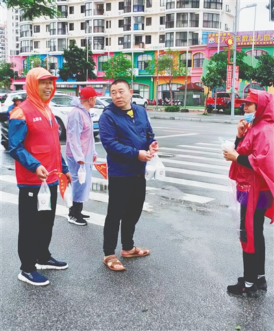 市民给张世青（左一）等队员送雨衣和豆浆。 （东方市新东方人志愿服务党支部供图）